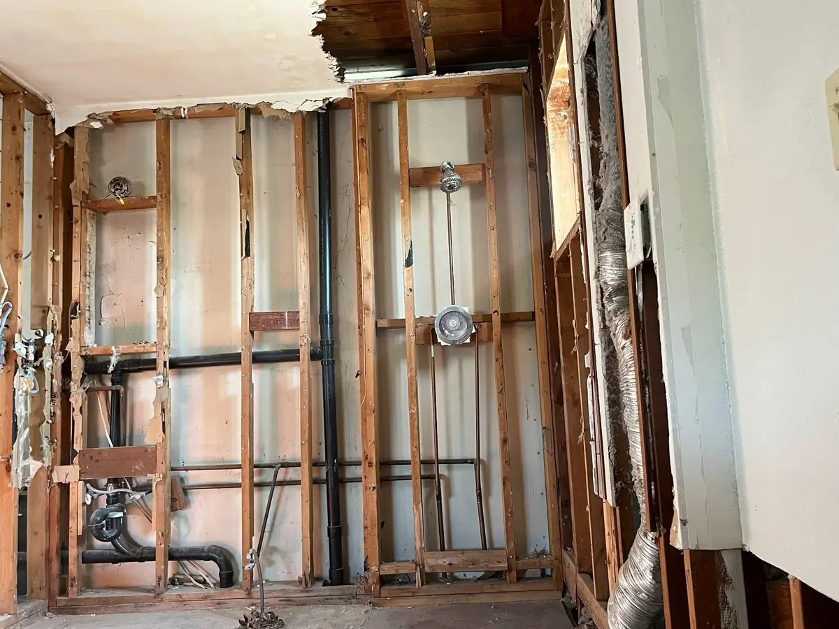 Bathroom stripped to the studs exposing plumbing for a remodel